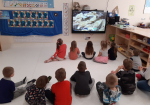 Dzieci oglądają na tablecie filmik dotyczący tradycji tłustego czwartku