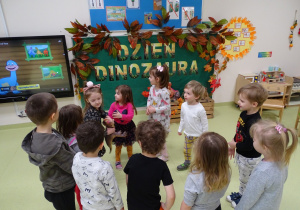 Dzieci podczas zabawy z dinozaurem