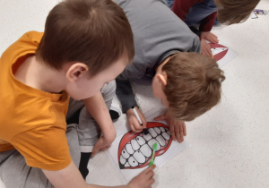 Dzieci wycierają plamki na ilustracji zębów