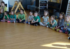 Dzieci siedzą na sali gimnastycznej