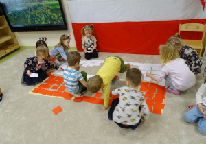 Dzieci układają flagę Polski z kartoników