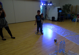 Chłopiec gra w kręgle z butelek po wodzie
