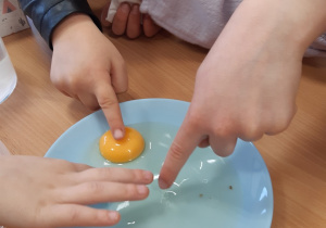 Dzieci dotykają białko i żółtko
