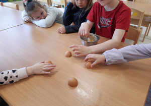 Dzieci dotykają skorupki jajek
