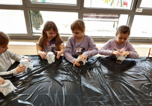 Dzieci przygotowują słoiczki do sadzenia fasolek