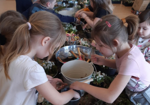 Dzieci wybierają dodatki do ozdobienia stroików