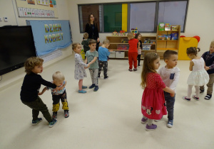 Dzieci tańczą w sali w parach.