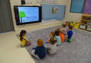 Dzieci oglądają film o kolorowej skarpetce.