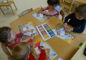 Dzieci kolorują skarpetki za pomocą pasteli wg własnego pomysłu.