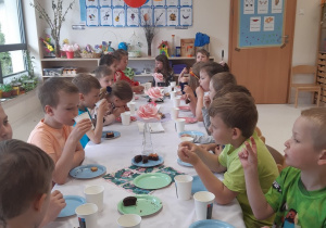 Dzieci jedzą ciastka i babeczki