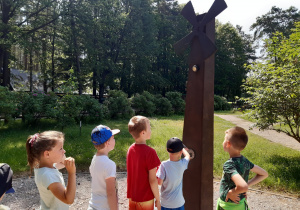 Dzieci kręcą korbą przy wiatraku i wytwarzają prąd