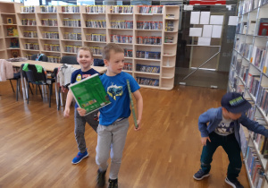 Chłopcy szukają poukrywanych książek o lesie