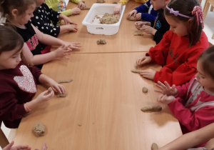 Dzieci lepią kształt liter z masy piaskowej