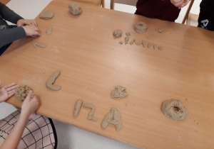 Dzieci ułożyły swoje imionka z masy piaskowej