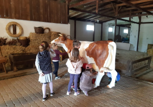 Dziewczynki podczas dojenia krowy