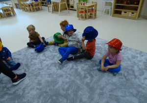 Dzieci zakładają na głowy kapelusze.