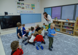 Dzieci podnoszą rozrzucone biedronki z podłogi.
