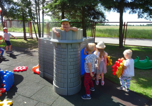 Dzieci bawią się w zamku na placu zabaw.