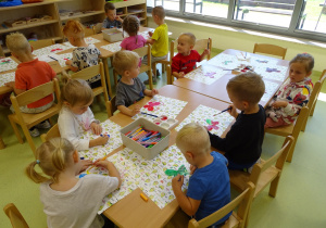 Dzieci malują motyle według własnego pomysłu.