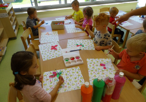 Dzieci malują motyle według własnego pomysłu.