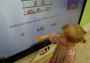 Martynka wybiera odpowiedni obrazek na monitorze.