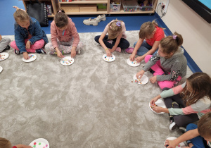 Dzieci układają kropeczki na talerzykach