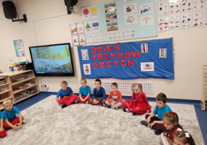 Dzieci ubrane w kolory flagi Wielkiej Brytanii siedzą w kole
