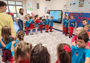 Dzieci tworzą autobus i tańczą do piosenki