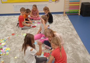 Dzieci układają obrazki z kolorowych kropek.