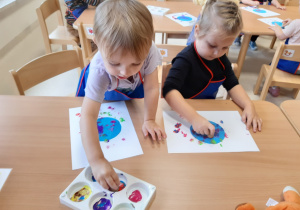 Dzieci stemplują farbami po kartce
