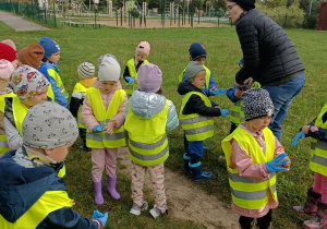 Pani zakłada dzieciom rękawiczki.