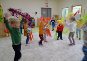 Dzieci tańczą z kolorowymi wstążkami.