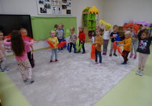 Dzieci tańczą z kolorowymi wstążkami.