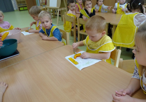 Dzieci obierają pieczoną dynię ze skórki.