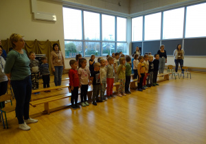 Dzieci stoją na baczność i śpiewają hymn.