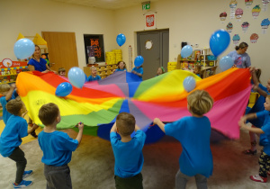 Dzieci podczas zabawy chustą z balonami