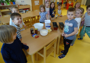 Dzieci stoją przy stole z produktami