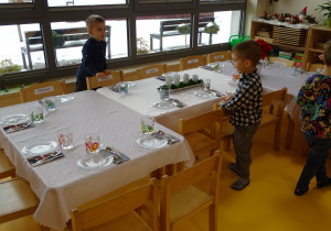 Chłopcy nakrywają stół