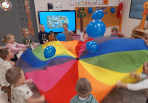 Dzieci podrzucają baloniki na chuście