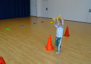 Dzieci ćwiczą na sali gimnastycznej ze swoimi misiami - tor przeszkód.
