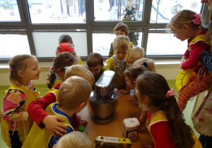 Dzieci obserwują, jak mieszają się składniki.