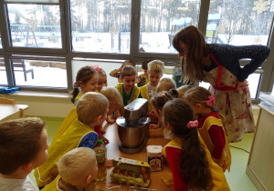 Dzieci obserwują, jak z wrzuconych składników powstaje ciasto.