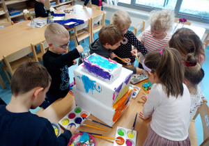 5-latki dekorują tort z pudełek