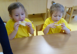 Dziewczynki jedzą wafelki z miodem