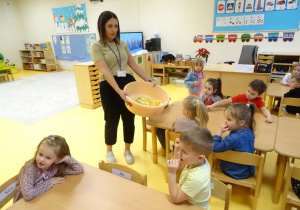 Nauczycielka trzyma dużą miskę z owocami
