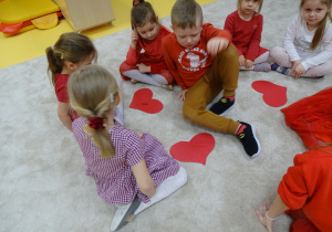 Dzieci siedzą z sercami