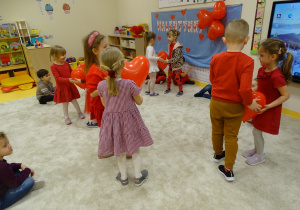 Dzieci tańczą z czerwonymi balonamik