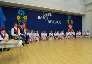 Dzieci siedzą na scenie