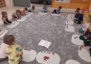 Dzieci wykonują zadanie matematyczne na dywanikach