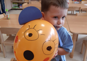 Chłopiec pozuje z balonikiem misiem